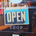 Photo of a storefront door with an 'Open Shop' sign.