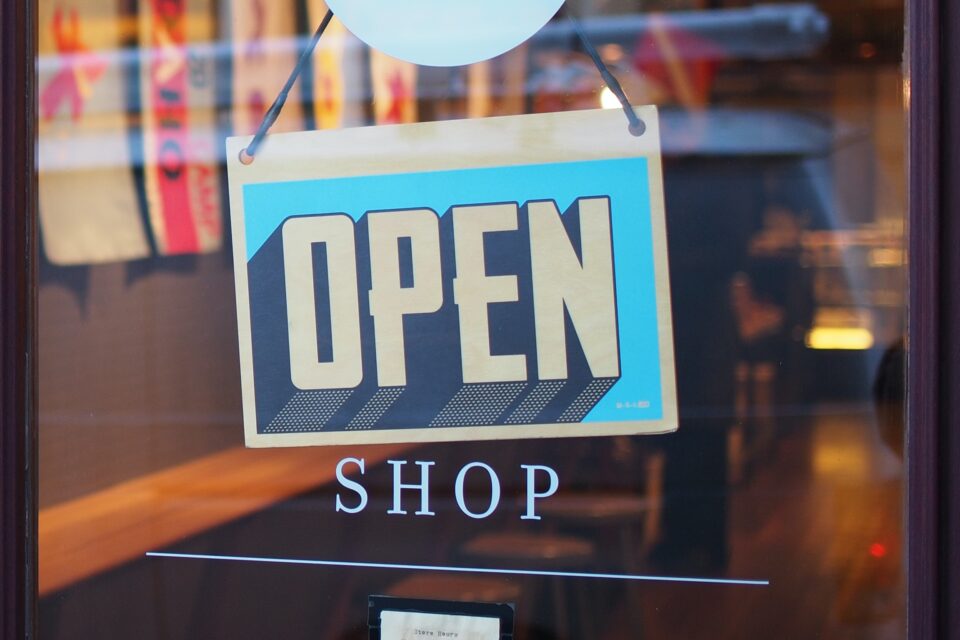 Photo of a storefront door with an 'Open Shop' sign.