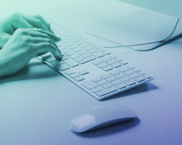 Photo of hands typing at a keyboard used as the feature image for an article titled 'Websites, word counts, and SEO—how many words do you actually need to rank well?'.